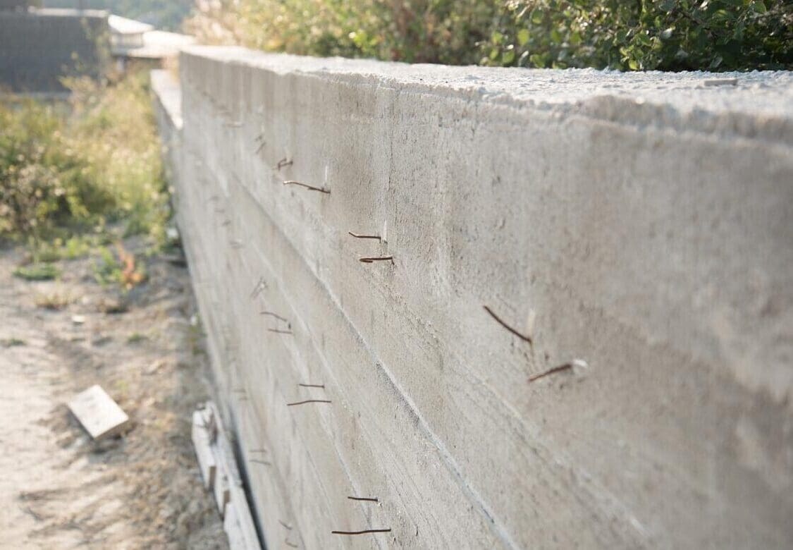 A construction wall with exposed nails protruding.