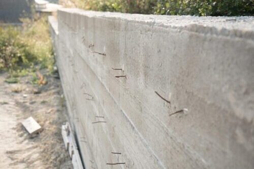 A construction wall with exposed nails protruding.