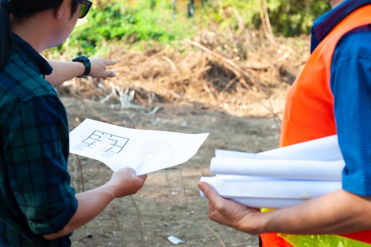 Group of contractors discuss land improvement planning for construction.