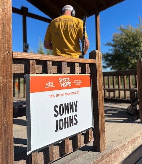 A Cardinal Strageties sponsor sign of Sonny Johnn on a wooden fence.