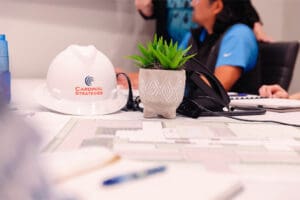 A Cardinal Strategies hard hat on the table in a conference room.