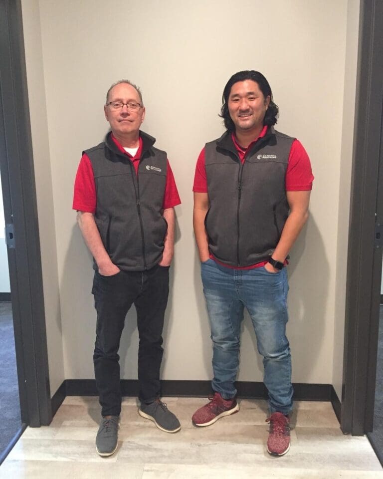 Two Cardinal Strategies employees sporting their new vests.