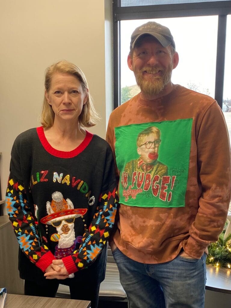 Judy and Calvin from Cardinal Strategies in funky Christmas sweaters.