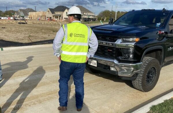 Mike from Cardinal Strategies standing in a reflective vest and hard hat onsite at a construction project.