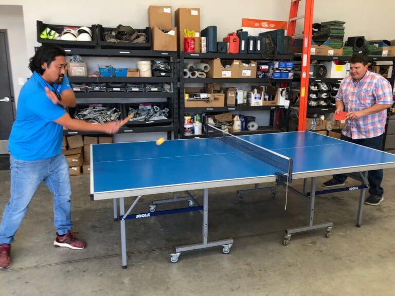 Two Cardinal Strategies employees playing ping pong.