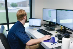 John Jacobs working at his desk on engineering designs