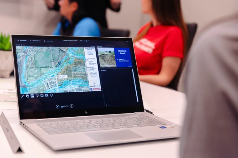 open laptop with topo map and people in the background
