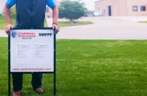 Home page: Person putting SWPPP sign in the ground